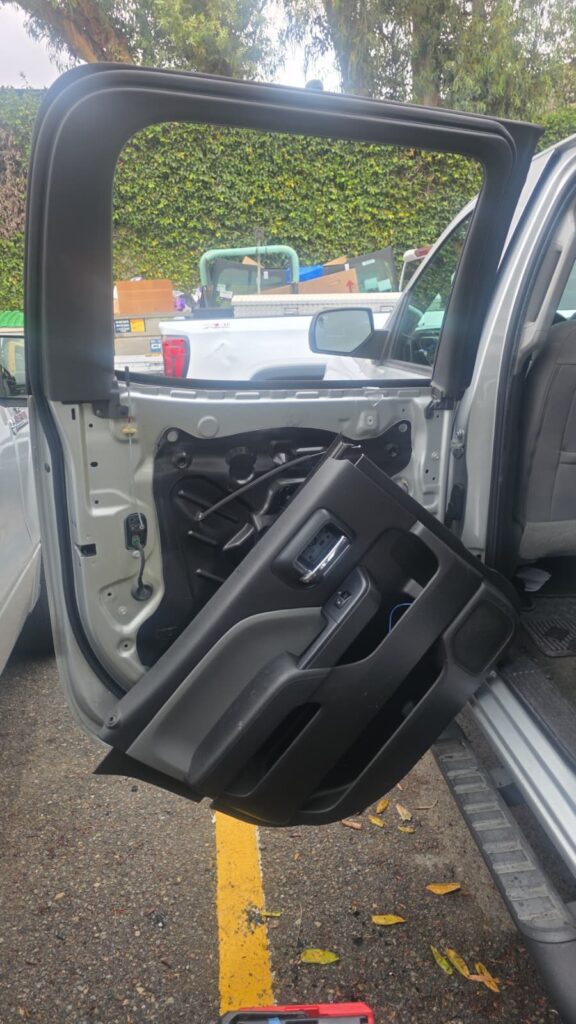 Chevy Silverado rear door with the panel removed by a Reyes Glass Group technician for door glass replacement